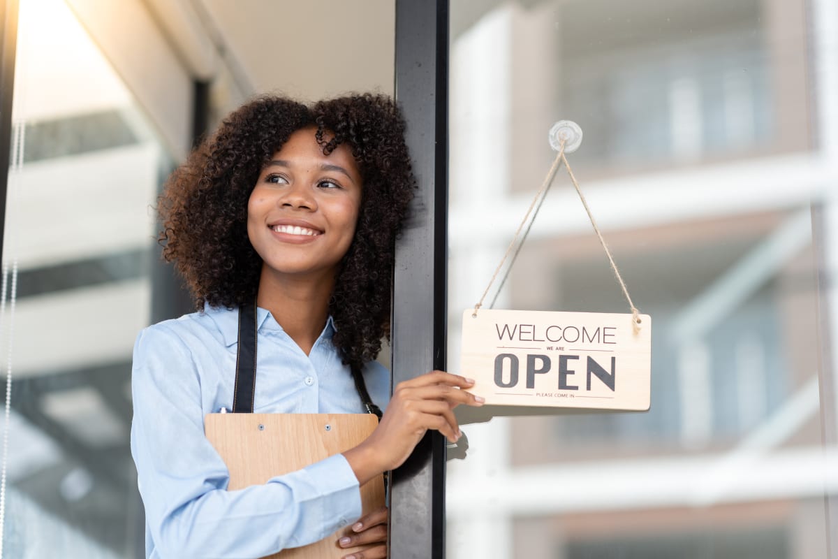 woman holding open sign