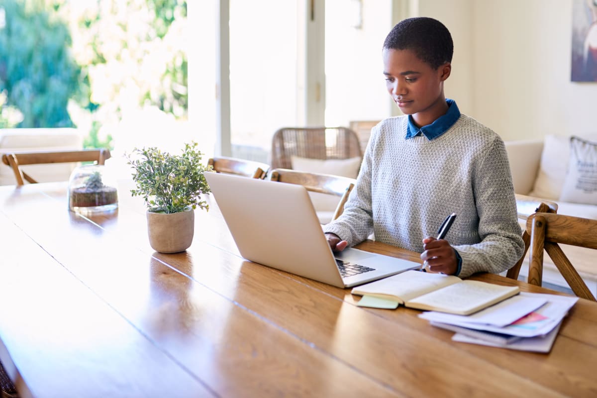 woman on laptop with notebooks